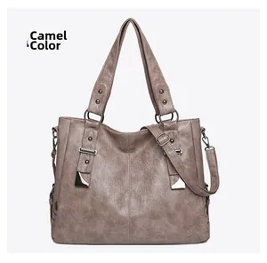 Macro detail of camel soft leather tote showing rivets and metallic hardware accents