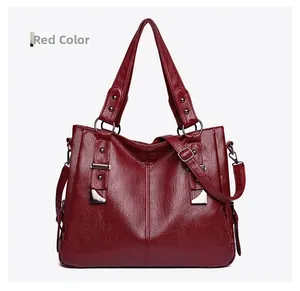 Detail of red faux leather tote bag showing glossy texture and silver rivet accents