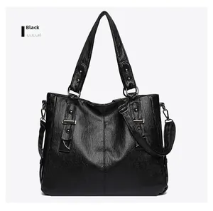 Detail of soft black faux leather tote with reinforced handles and silver metal hardware