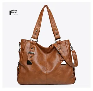 Detail view of tan leather tote bag with silver hardware and adjustable shoulder strap