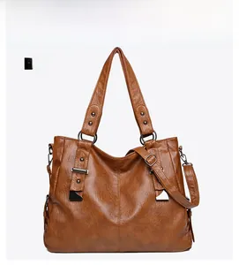 Front view of brown vintage leather tote bag with rivets and metal ring handles