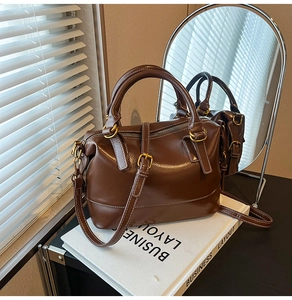 Vue détaillée d'un sac Boston vintage marron avec surpiqûres blanches et métal doré