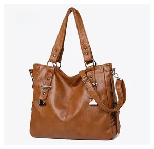 Detailed 45-degree side view of a brown vintage PU leather tote bag with silver rivets