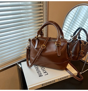 Vue détaillée du sac Boston en cuir marron foncé avec ferrures vintage et bandoulière