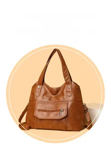 Detailed view of brown PU leather tote bag with silver zipper and rivet embellishments
