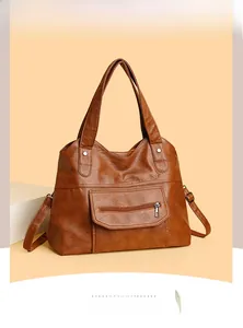 Detail of large brown PU leather tote bag featuring a front pocket and soft lychee texture