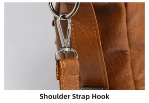Macro view of silver metal shoulder strap hook and textured brown faux leather bag