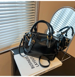 Détail du sac Boston noir avec surpiqûres blanches contrastées et cuir ciré à l'aspect poli