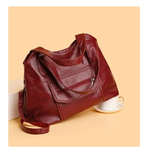 Detail view of burgundy large PU leather tote bag with silver zipper and pebbled texture