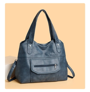 Detailed view of the dark blue PU leather tote bag with a front zipper pocket and strap