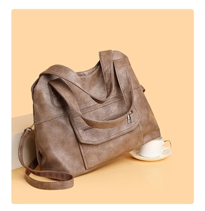 Detail of soft dark brown PU leather tote bag with zip pocket and detachable strap