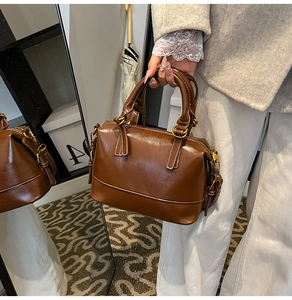Détail du sac Boston vintage en cuir ciré marron avec finitions dorées et poignées