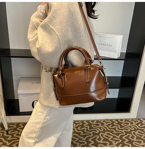 Vue détaillée du sac Boston en cuir marron foncé avec surpiqûres blanches contrastées