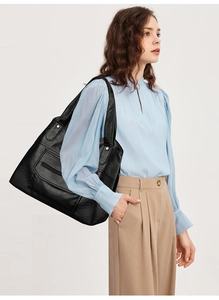 Close-up of black PU leather tote bag featuring litchi grain texture and zipper pocket