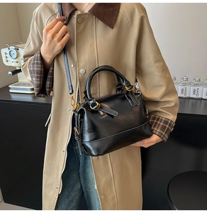 Détail du sac Boston vintage en cuir ciré avec finitions dorées et poignée supérieure