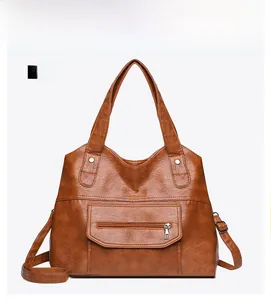 Front view of brown PU leather tote bag with functional zippers and long strap