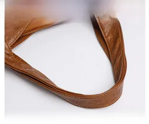 Detailed macro view of litchi texture PU leather with precise stitching and handles