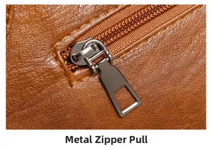 Close-up of durable metal zipper pull and textured brown PU leather on tote bag