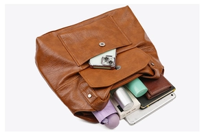 Detail showing the large capacity of the tan PU leather tote bag with various daily items