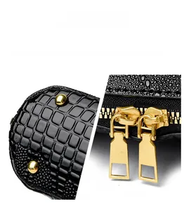 Macro view of double gold zippers and protective spherical studs on black leather bag