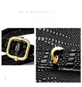 Detail of a shiny black crocodile pattern leather strap with elegant gold square buckle