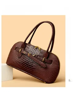 Detail of brown crocodile pattern handbag with gold hardware and dual zippers