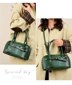 Detail of dark green crocodile texture leather bag with elegant gold zipper and hardware