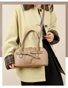 Detail of khaki croc-embossed tote bag with gold hardware and stylish top handles