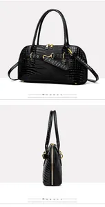 Detail of black faux crocodile leather handbag with golden hardware and double zippers