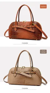 Detail view of crocodile pattern shoulder bags in brown and khaki with golden hardware