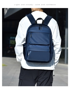 Outdoor shot of a navy blue waterproof backpack featuring dual front zipper pockets