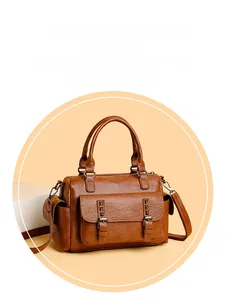Détail du sac Boston en similicuir marron avec texture lychee et rivets métalliques