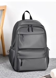 Detail of dark grey waterproof nylon backpack with dual front zip pockets and side pockets