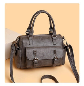 Gros plan du sac Boston gris foncé avec boucles vintage et clous métalliques élégants