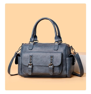 Détail du sac à main bleu en similicuir grainé avec rivets et boucles métalliques