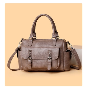 Gros plan d'un sac vintage en cuir marron avec rivets métalliques et bandoulière réglable