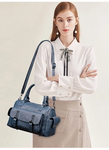 Détail de la texture cuir PU bleu vintage et des poches à rivets élégantes du sac
