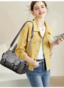 Détail du sac rétro gris foncé en cuir avec plusieurs poches et boucles métalliques