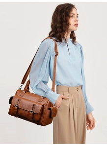 Sac à bandoulière rétro marron avec rivets, présenté dans un contexte de mode élégant