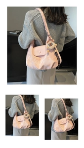 Detail der rosa Falten-Tasche mit Löwen-Anhänger und weicher PU-Textur am Model