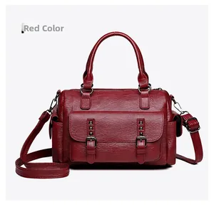 Détail du sac messager rouge avec cuir texture litchi et boucles métalliques