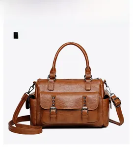 Vue de face du sac à main en cuir marron avec rivets et bandoulière amovible