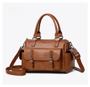 Détail d'un sac Boston marron rétro avec poches à boucles rivetées et poches latérales