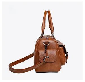 Vue latérale du sac en simili cuir marron avec fermeture éclair et poche à boucle