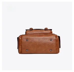 Détail du fond de sac rétro marron avec quatre rivets de protection en métal brossé