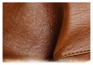 Gros plan sur la texture du cuir marron et les coutures de ce sac bandoulière vintage