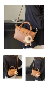 Brown lychee leather tote bag with boutique embossing and a plush sheep pendant detail