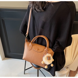 Detailansicht braune Tasche mit Schaf-Anhänger und verstellbarem Schultergurt