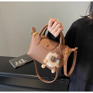 Braune Handtasche aus Litschi-Leder mit Logoprägung und einem süßen Lamm-Anhänger