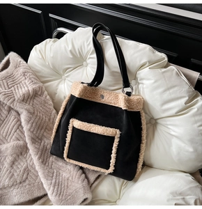 Detail of vintage black suede tote bag with beige plush trim and metal ring strap detail